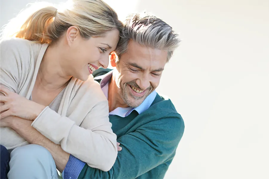 A happy middle-aged couple embracing in the sunlight. Get Hormone Replacement Therapy from ProCare Wellness Institute in Savannah.