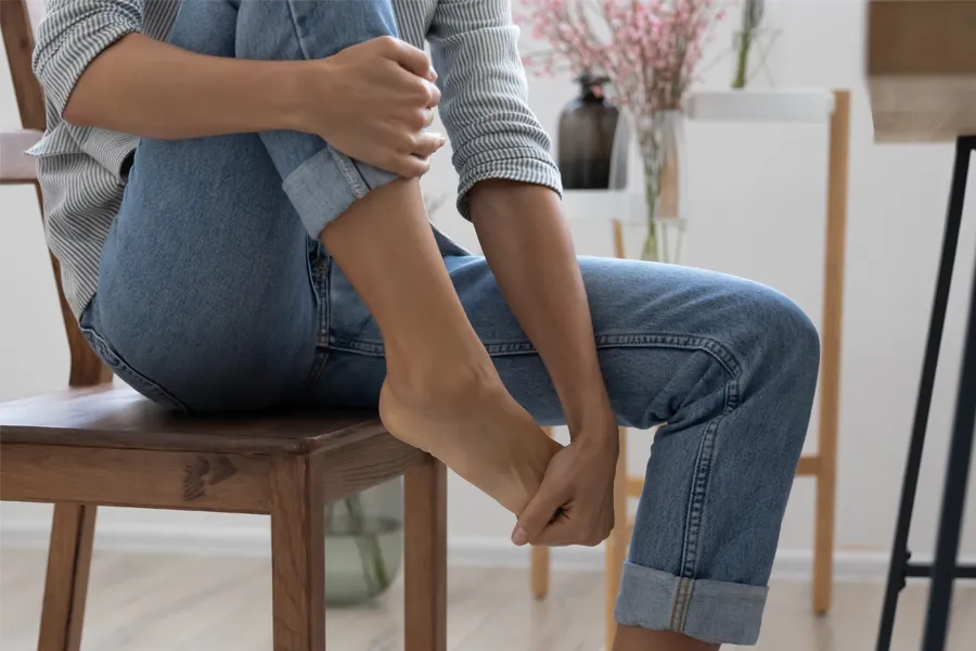 Diabetic-Neuropathy-Clinic A woman sits and rubs her aching foot. Get treatment for Diabetic Neuropathy from ProCare Wellness Institute in Savannah.