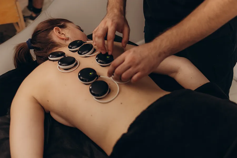 High-Frequency-Electroanalgesic-Therapy-Clinic Woman lying face down on a massage table receiving High Frequency Electroanalgesic Therapy in Savannah.