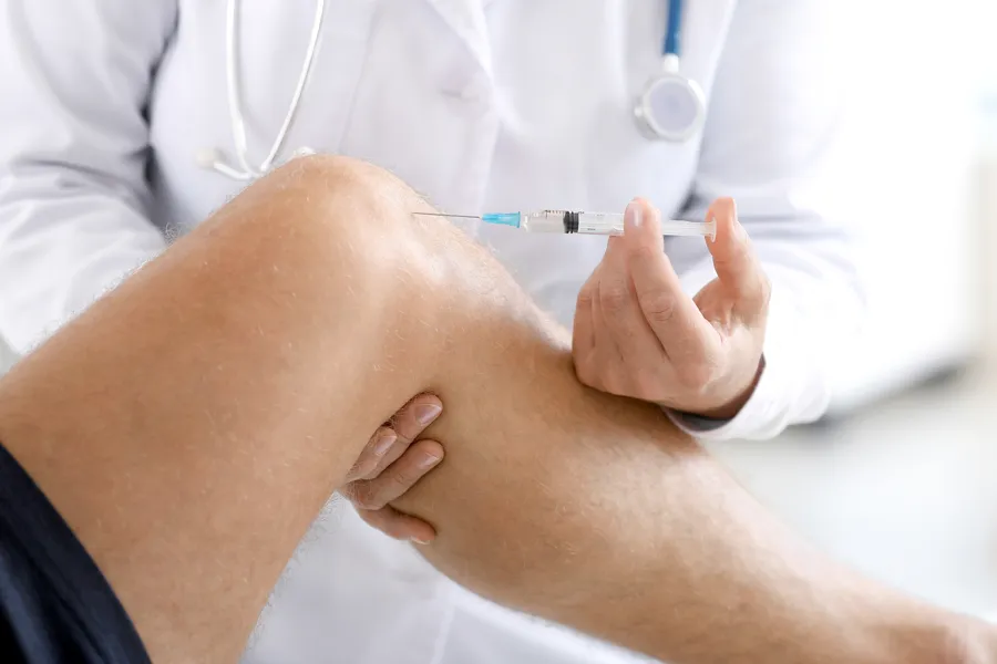 Hyaluronic-Acid-Injections-Clinic A man receives an injection in his name from a clinician. Schedule Hyaluronic Acid Injections Treatment from ProCare Wellness Institute in Savannah.