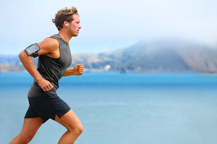Hyaluronic-Acid-Injections-for-Knee-Pain-Clinic A focused young man running pain-free along a coastal path with a scenic view of the sea after receiving Hyaluronic Acid Injections for Knee Pain by ProCare Wellness Institute in Savannah.