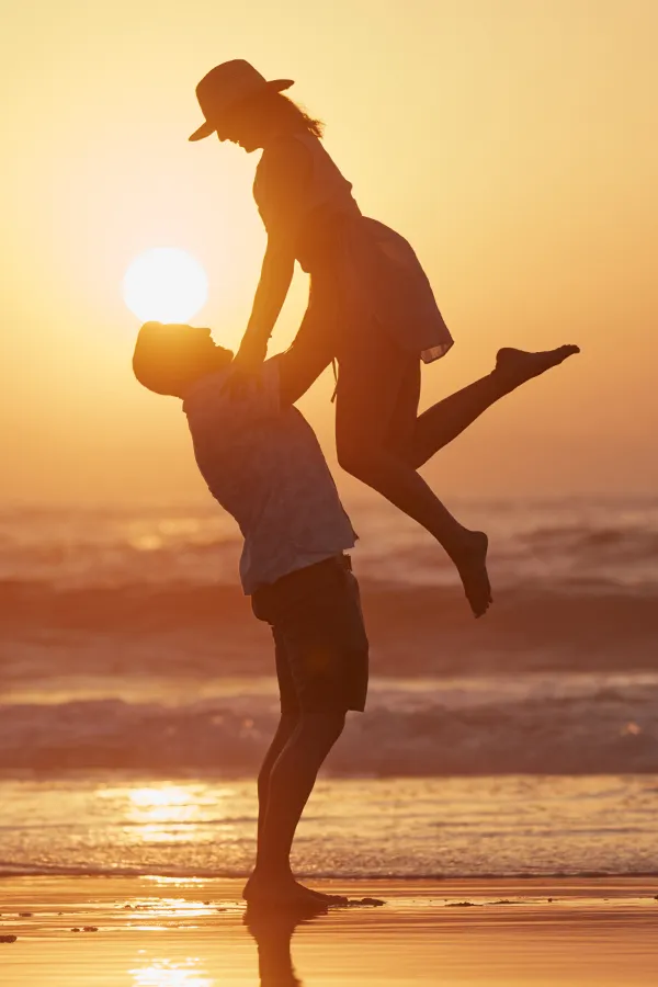 LCL-Tears-Treatment A man lifts a woman into the air on the beach. Get treatment for LCL tears from ProCare Wellness Institute in Savannah.