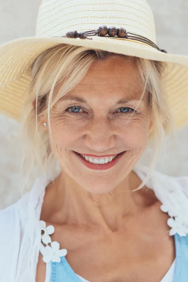 Menopause-Treatment A beautiful, smiling older woman with blonde hair and a sunhat, happy with menopause treatment from ProCare Wellness Institute in Savannah.