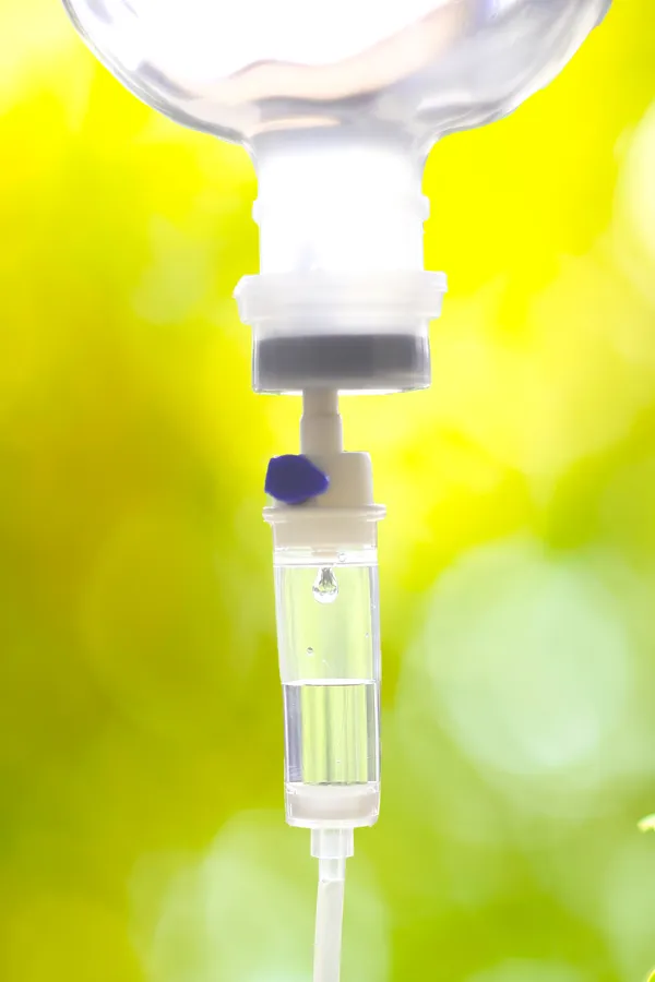 NAD-Therapy-Treatment Close up of an IV drip with a lush, green background. Get NAD Therapy from ProCare Wellness Institute in Savannah.