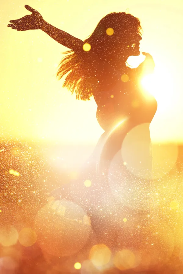 Neuromodulation-Treatment Silhouette of a joyful woman dancing, with her arms outstretched and her hair flowing. She is backlit by a warm, golden sunset that creates a glowing effect around her figure. She is uplifted by the expert Neuromodulation Therapy Treatment she has received by ProCare Wellness Institute in Savannah.