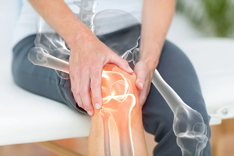 Osteoarthritis-Clinic A 3D illustration of the skeleton over the body of a woman who holds her knee in pain, where the area is highlighted. Schedule osteoarthritis treatment from ProCare Wellness Institute in Savannah.