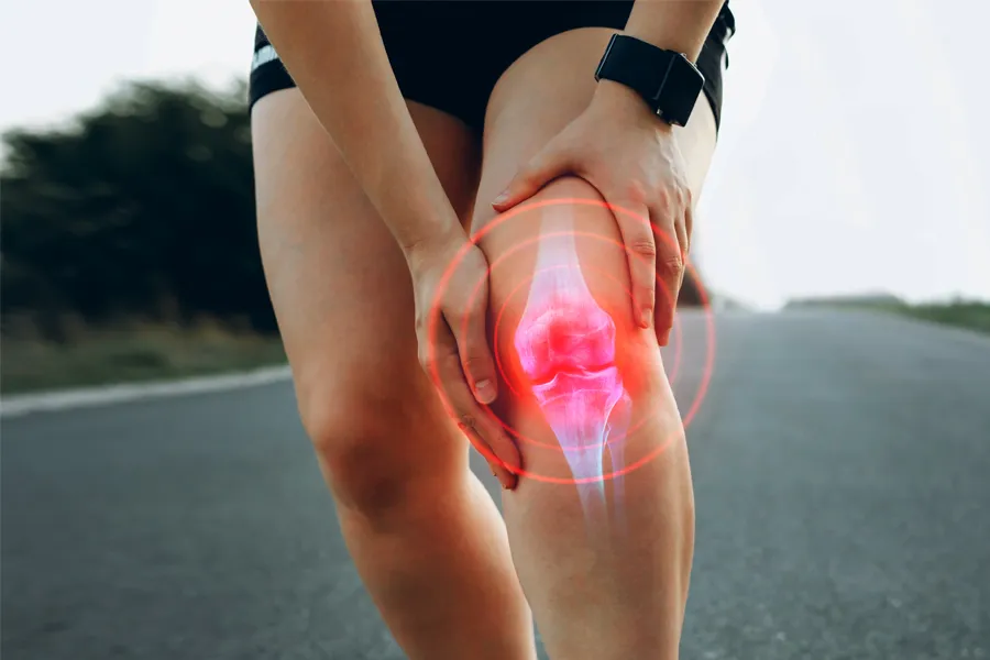 Close up of a female jogger holding her knee with an illustration of the knee joint with red radiating circles indicating pain, which can be relieved with PRP treatment for knee pain from ProCare Wellness Institute in Savannah.