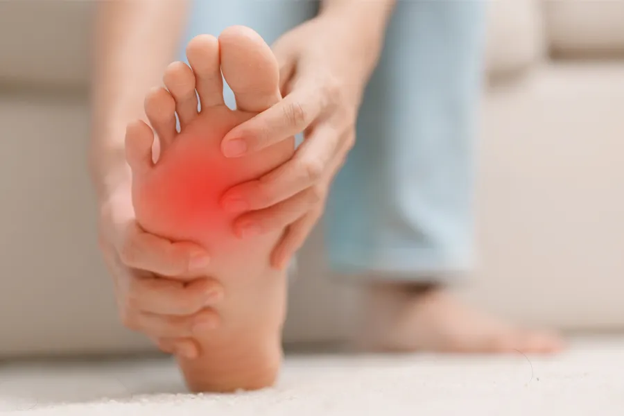 Plantar-Fasciitis-Clinic A woman holds her foot in pain. Schedule plantar fasciitis treatment from ProCare Wellness Institute in Savannah.